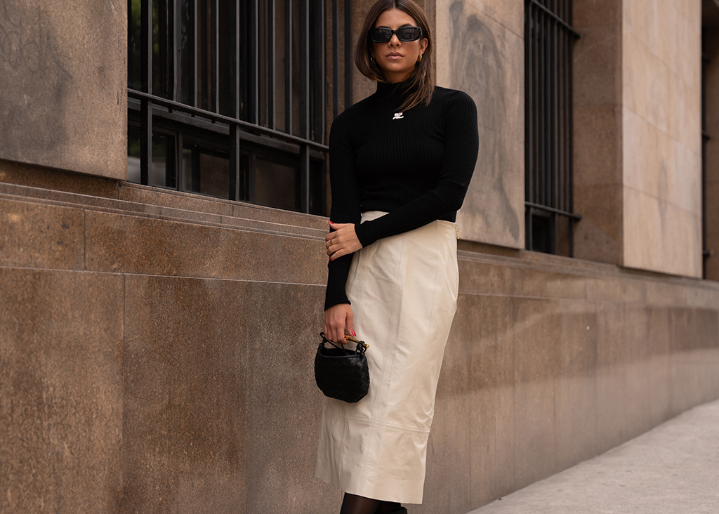 Look com saia midi de couro off-white e blusa preta