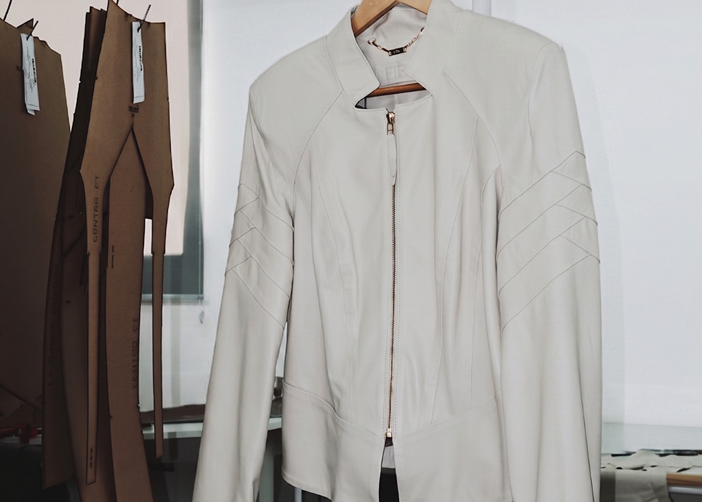 Jaqueta de couro off-white em cabide na fábrica